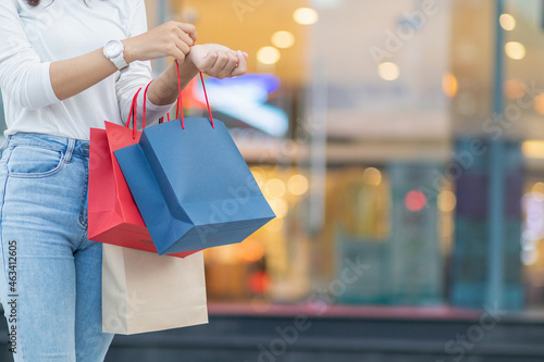 A young woman holding a shopping bag after going shopping for discounted items in a department store as the New Year's holiday approaches, there is a promotion on sale. shopping concept