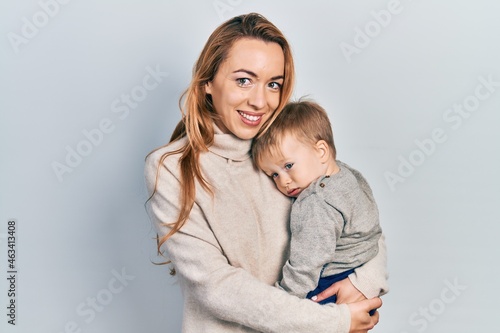 Young caucasian woman holding and hugging her son with love. Family of two bonding together. Mother holding infant toddler