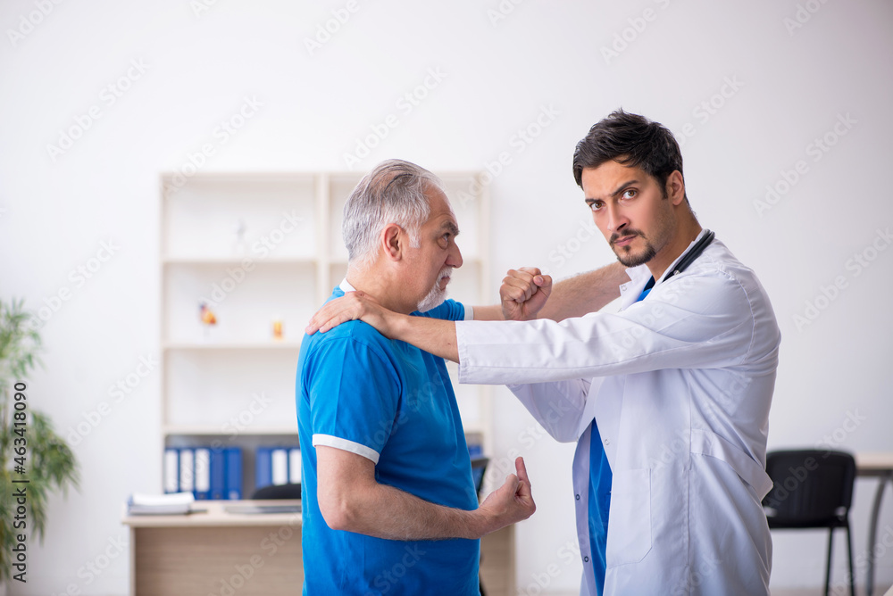 Old male patient visiting young male doctor Old male patient visiting young male doctor
