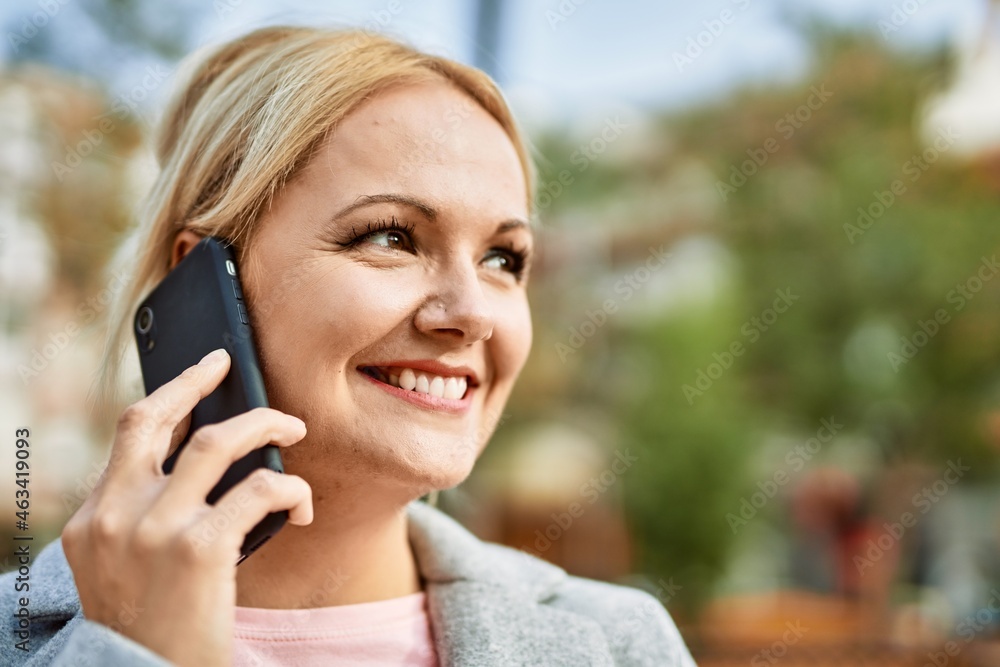 Young blonde businesswoman smiling happy talking on the smartphone at the city. Young blonde businesswoman smiling happy talking on the smartphone at the city.