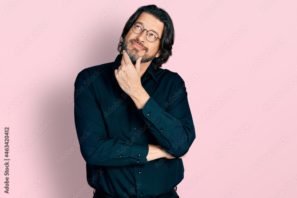 Middle age caucasian man wearing casual clothes and glasses with hand on chin thinking about question, pensive expression. smiling with thoughtful face. doubt concept. Middle age caucasian man wearing casual clothes and glasses with hand on chin thinking about question, pensive expression. smiling with thoughtful face. doubt concept.