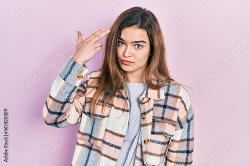 Young caucasian girl wearing casual clothes shooting and killing oneself pointing hand and fingers to head like gun, suicide gesture. © Krakenimages.com