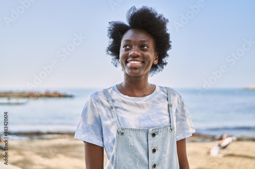 Young african woman smiling confident by the sea