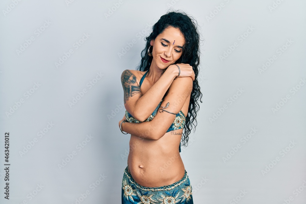 Young woman wearing bindi and traditional belly dance clothes hugging oneself happy and positive, smiling confident. self love and self care Young woman wearing bindi and traditional belly dance clothes hugging oneself happy and positive, smiling confident. self love and self care