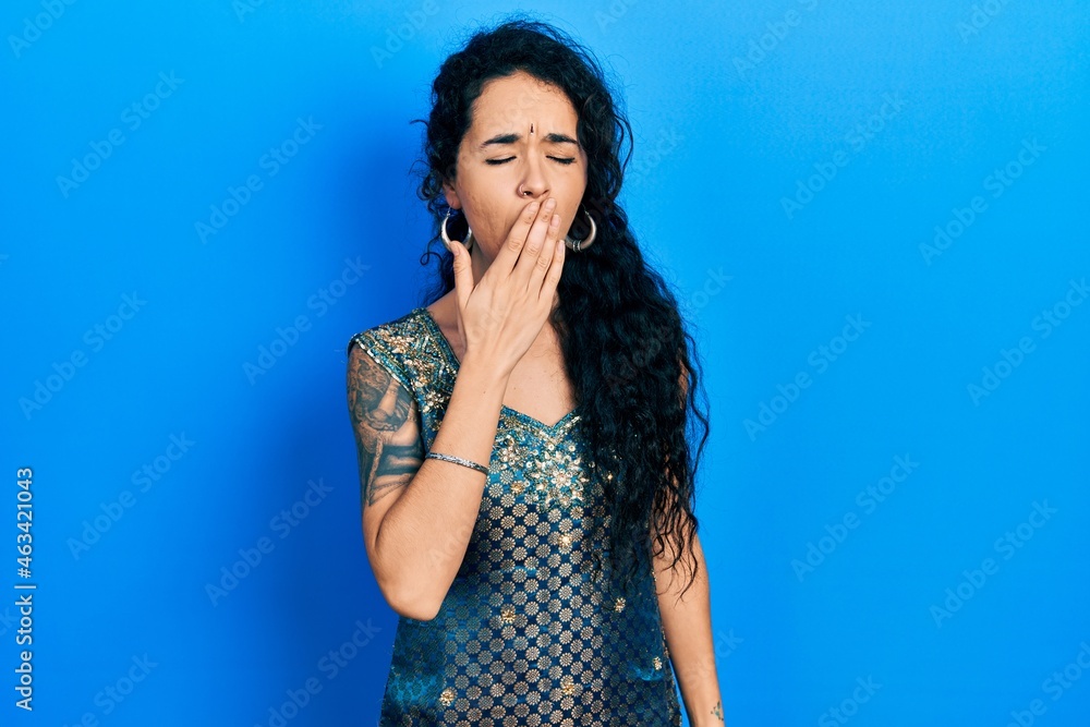 Young woman wearing bindi and traditional kurta dress bored yawning tired covering mouth with hand. restless and sleepiness. Young woman wearing bindi and traditional kurta dress bored yawning tired covering mouth with hand. restless and sleepiness.