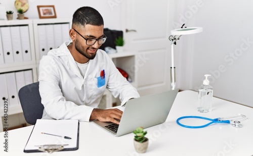 Young arab man wearing doctor uniform working at clinic