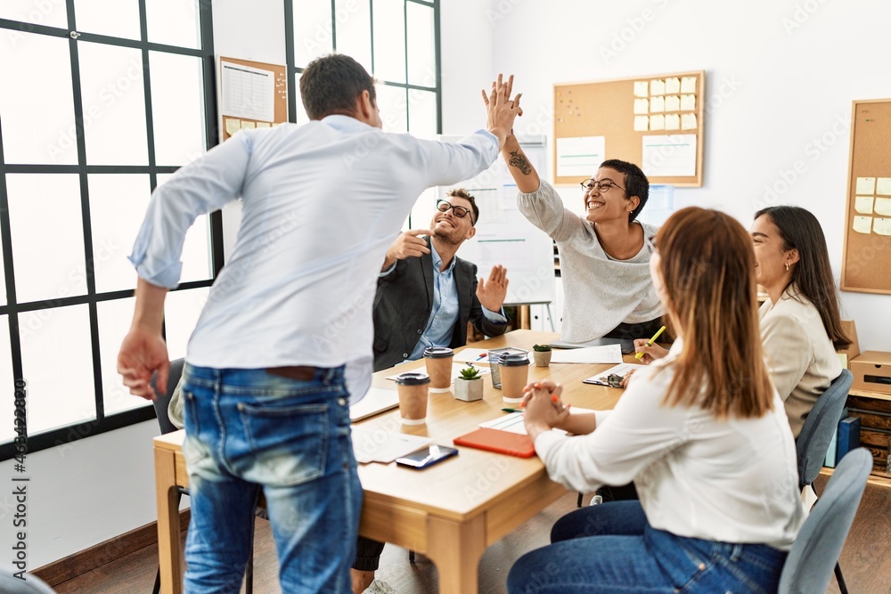 Fototapeta premium Two workers smiling happy high five during meeting at the office.