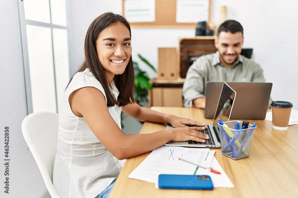 Two latin business workers smiling happy working at the office. Two latin business workers smiling happy working at the office.