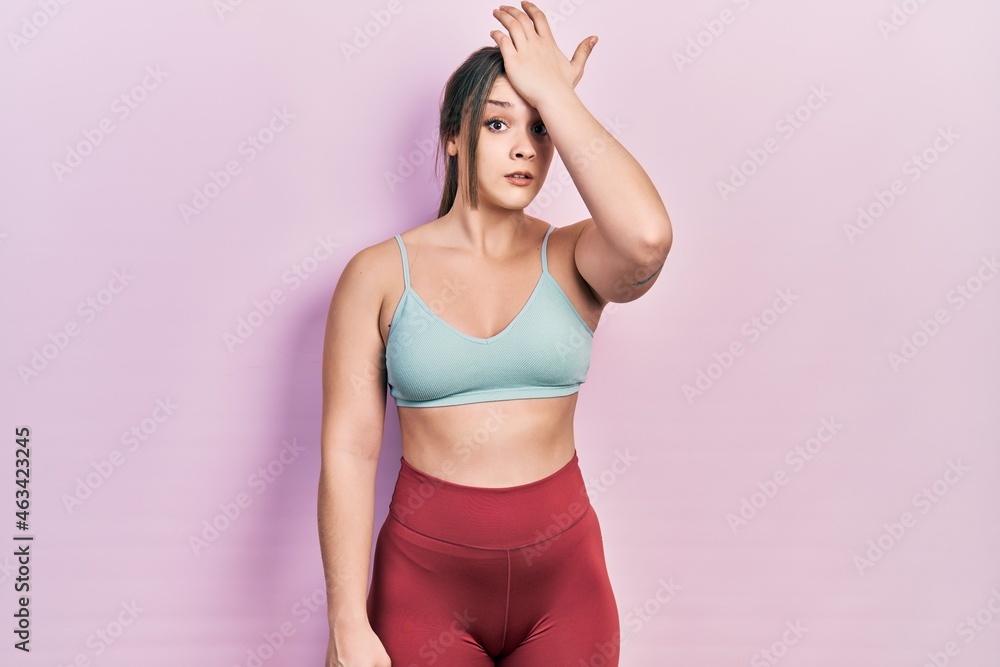 Young hispanic girl wearing sportswear surprised with hand on head for mistake, remember error. forgot, bad memory concept. Young hispanic girl wearing sportswear surprised with hand on head for mistake, remember error. forgot, bad memory concept.
