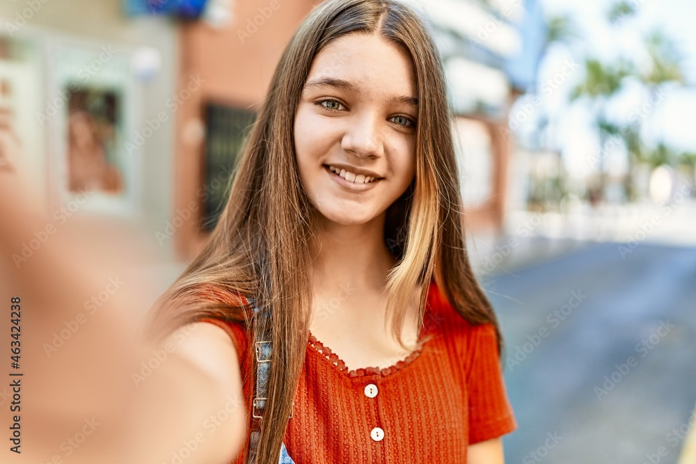 Caucasian teenager girl smiling happy make selfie by the smartphone at the city. Caucasian teenager girl smiling happy make selfie by the smartphone at the city.