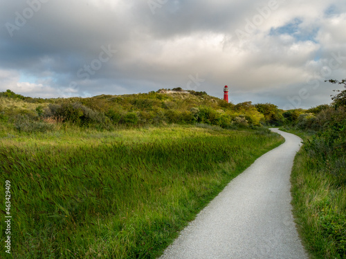 Red Lighthouse at Schiermonnikoog. Noordertoren. with beautiful scenery, lights and heavy sky in the dunes
 photo