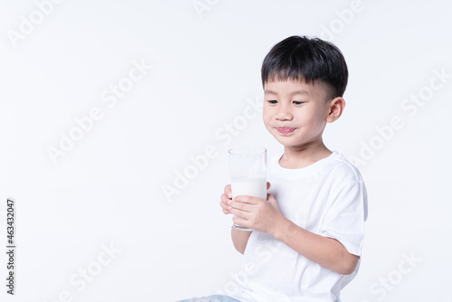 Asian boy drinking milk from glass