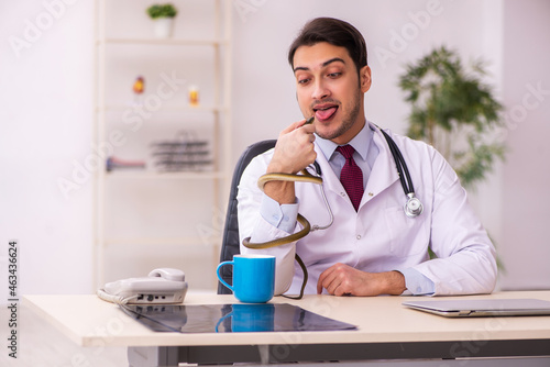 Wallpaper Mural Young male doctor holding snake in the clinic Torontodigital.ca