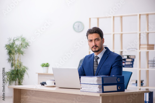 Young handsome employee working in the office