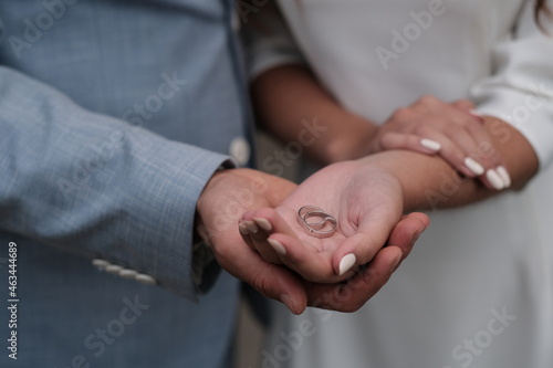 the hands of the bride and groom hold the rings