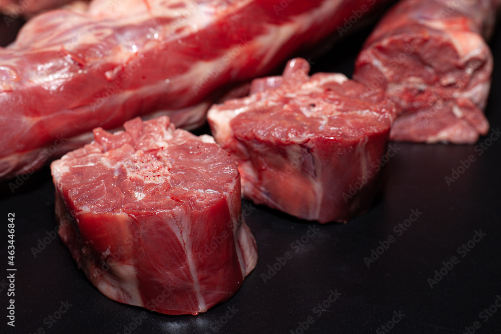Fototapeta premium Pieces of turkey neck with bone. Organic turkey meat with greens