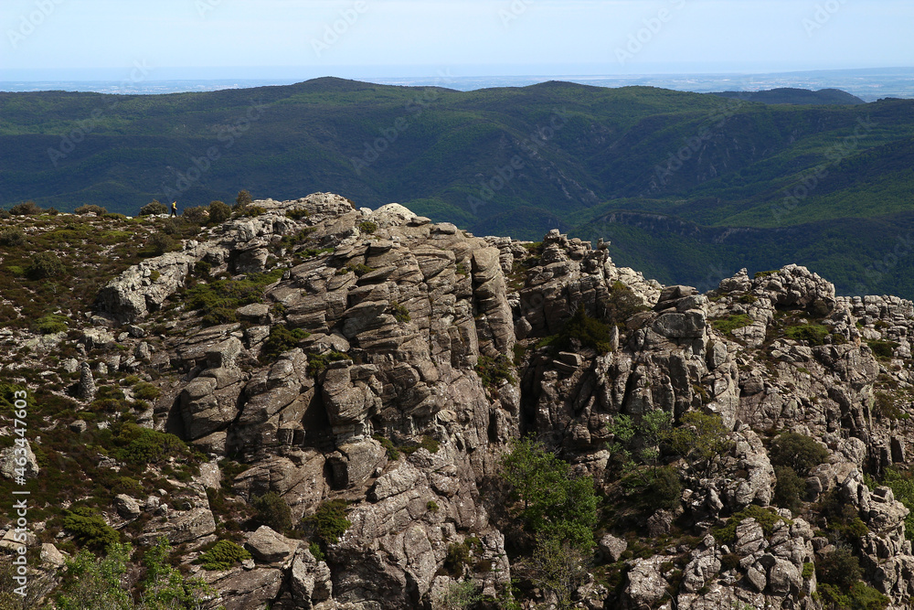 The tiny silhouette of a hiker can be seen on a ridge from the Caroux plateau, near the Colombières gorges (Hérault, Haut Languedoc, France).