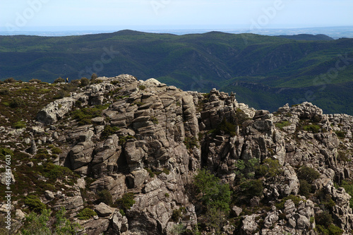 The tiny silhouette of a hiker can be seen on a ridge from the Caroux plateau, near the Colombières gorges (Hérault, Haut Languedoc, France).