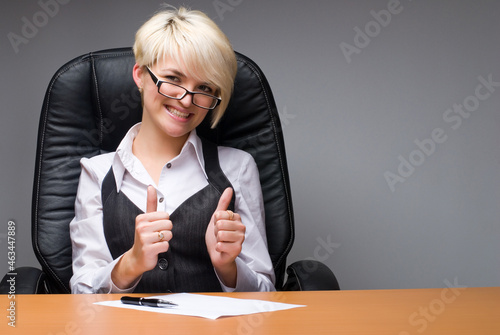 Young business lady showing thums up gesture photo
