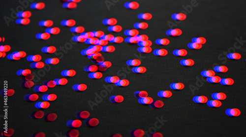 Vibrant glowing metallic circle confetti decoration on a black background. Glitch effect. Festive backdrop. Rgb shift. Retro effect.