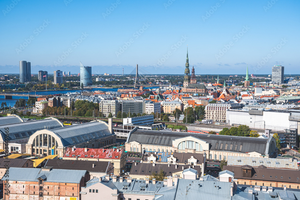 Riga panorama with St. Peter's Church and other churches and buildings, Daugava river, bridge, financial district and Central Market 