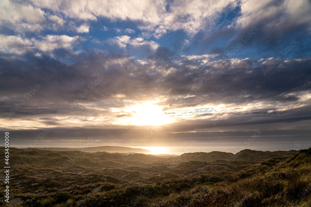 As the sun set over the Pacific Ocean the beautiful grass covered sandy hills lit up As the sun set over the Pacific Ocean the beautiful grass covered sandy hills lit up