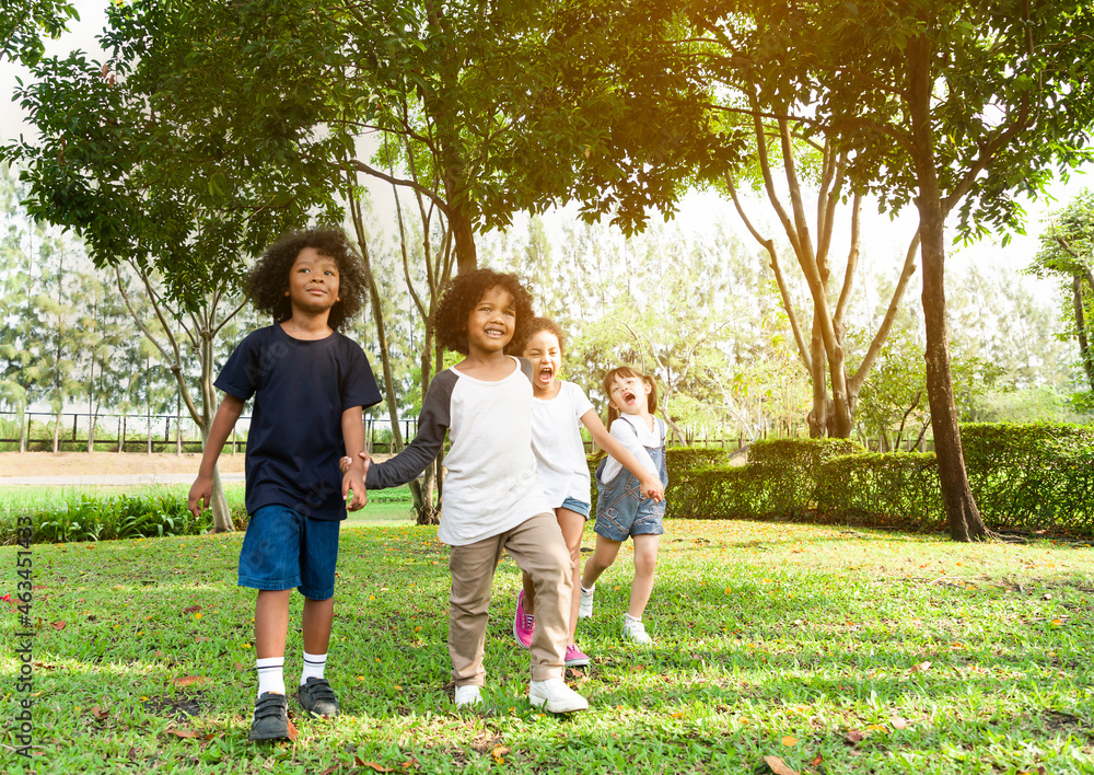 Fototapeta premium Group of diversity kids playing cheerful in the park. Children having fun and jumping with rope in the garden.