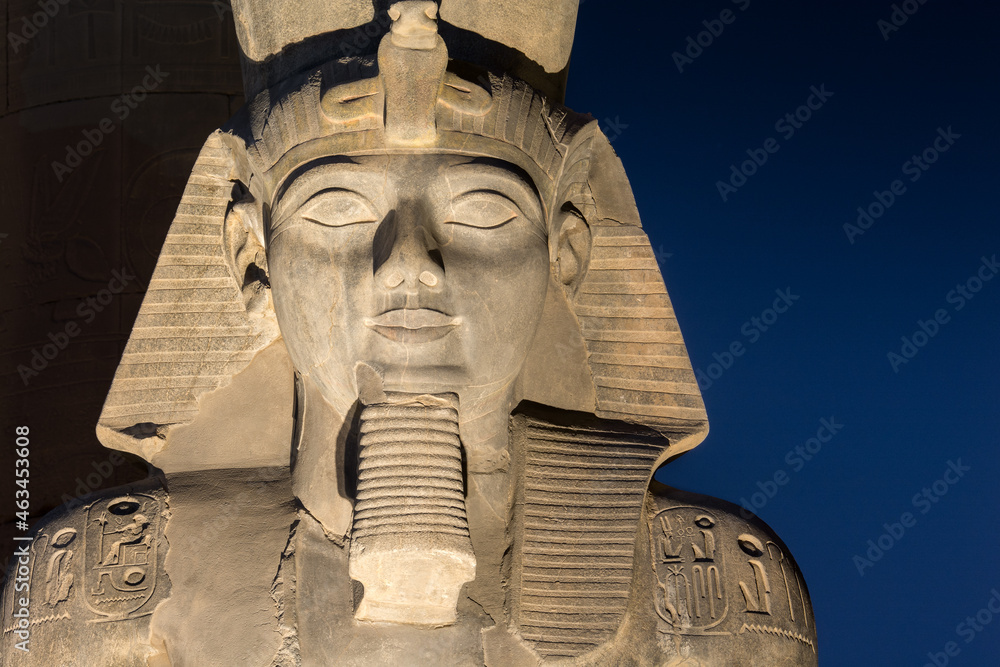 The statue of Ramesses II Illuminated at night in the temple of Luxor - obrazy, fototapety, plakaty 