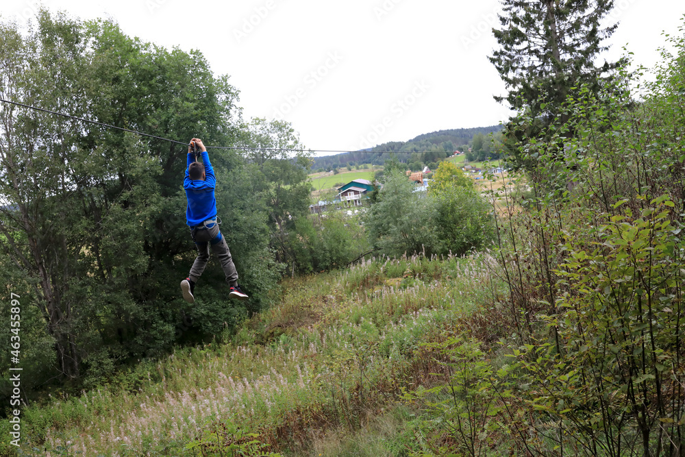 Kid rolling on zipline in forest Kid rolling on zipline in forest