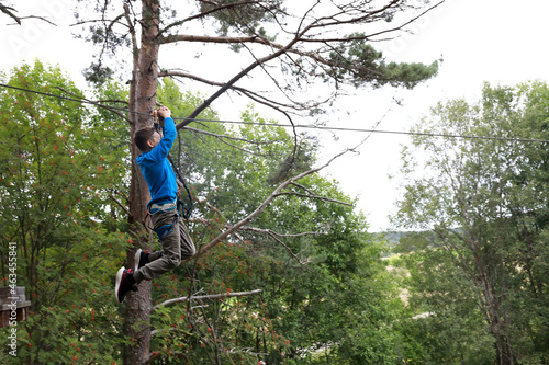 Boy rolling on zipline in forest