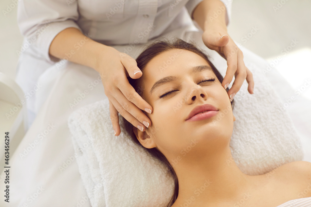 Close up of cosmetologist make face lifting massage to woman client in beauty salon. Dermatologist do facial skincare procedures for healthy glowing skin for female patient. Cosmetology concept. Close up of cosmetologist make face lifting massage to woman client in beauty salon. Dermatologist do facial skincare procedures for healthy glowing skin for female patient. Cosmetology concept.