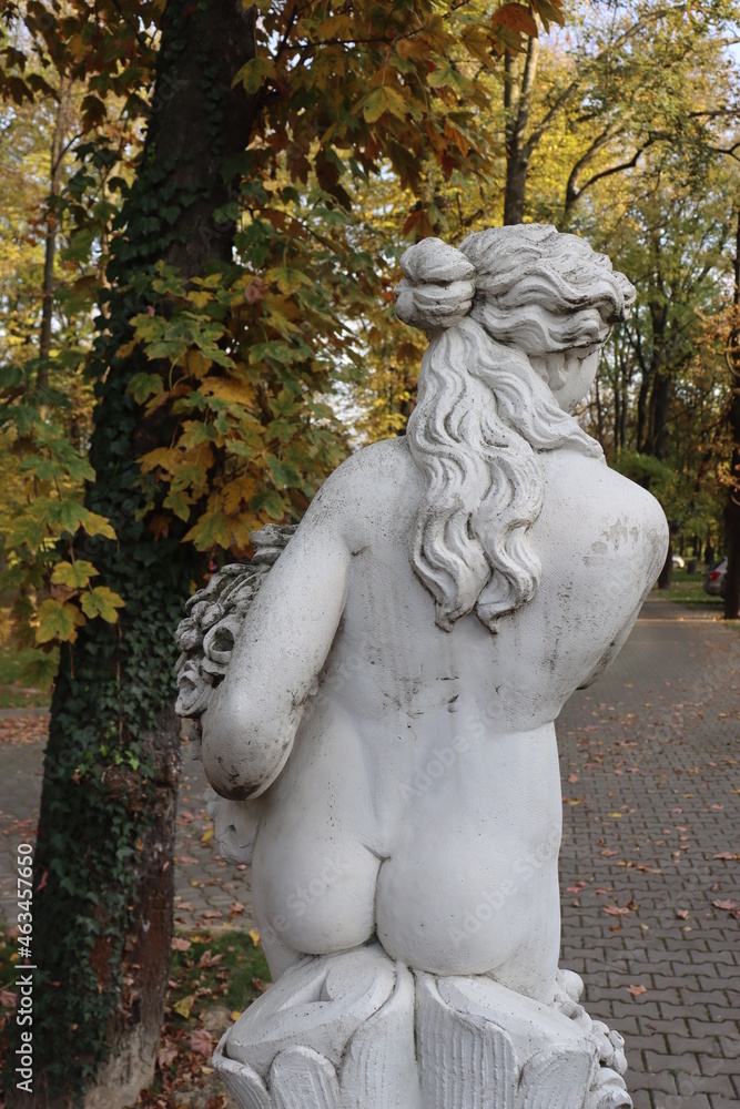 statue of a girl with flowers and grapes in a basket half-naked greek sculpture