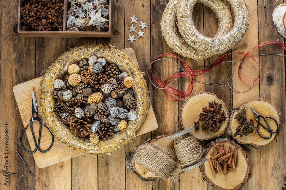 Dekoration Weihnachten - Strohkranz gefüllt mit verschiedenen natürlichen Zapfen daneben Zimt Anis und kleine Zapfen auf Holzscheibe Dekoration Weihnachten - Strohkranz gefüllt mit verschiedenen natürlichen Zapfen daneben Zimt Anis und kleine Zapfen auf Holzscheibe