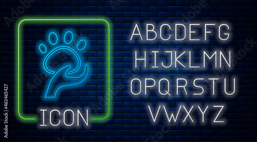 Glowing neon Animal volunteer icon isolated on brick wall background. Animal care concept. Neon light alphabet. Vector