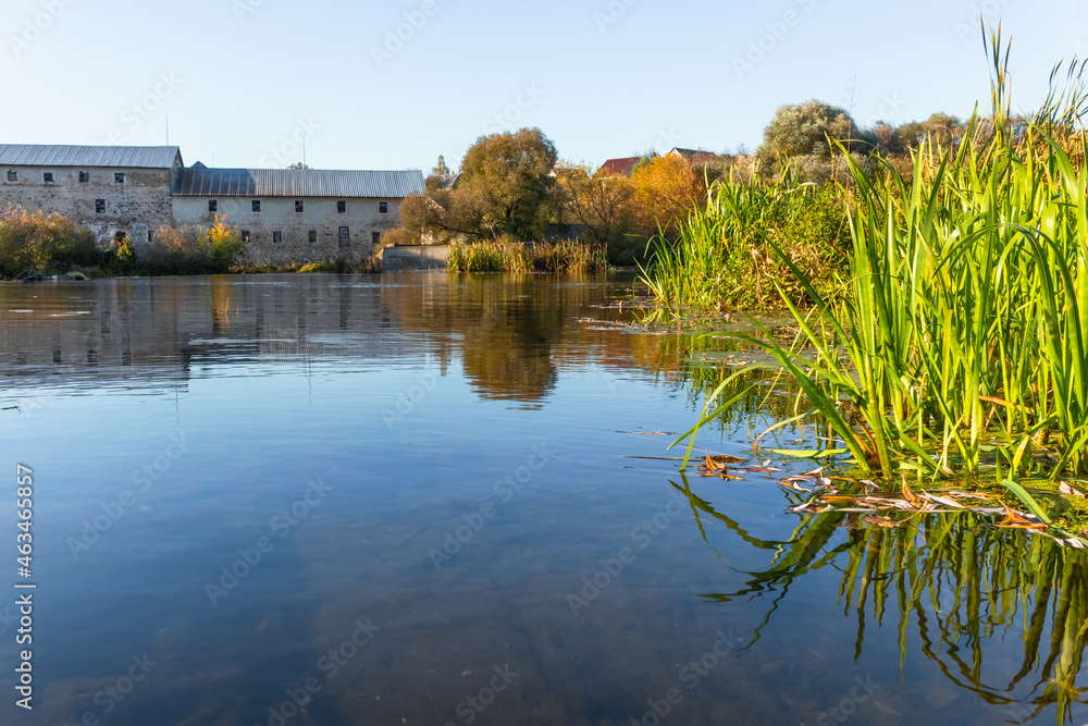 A picturesque view from the shore of the reflection in the river on a sunny autumn day.
