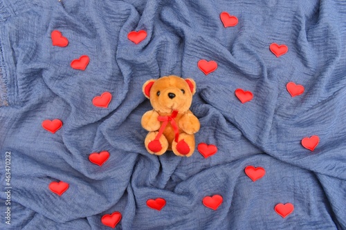 teddy bear toy on the blue background with red hearts