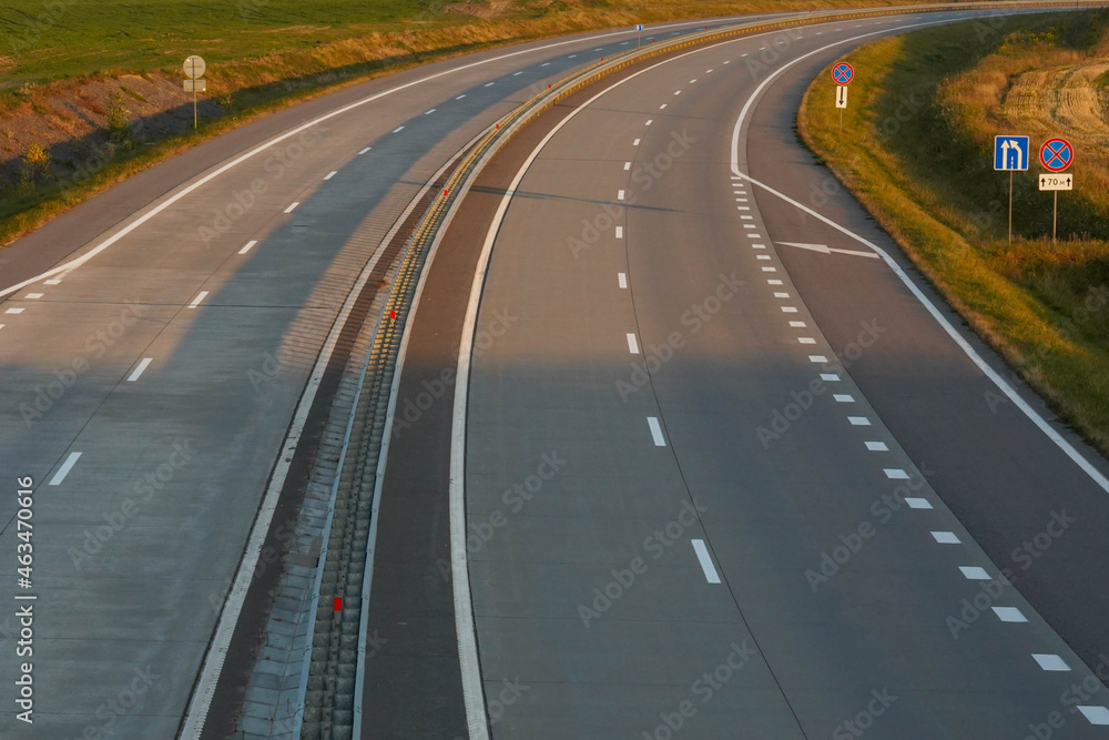 Photo of a gray road with white road markings Photo of a gray road with white road markings