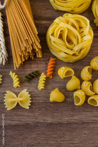 Various of uncooked pasta or macaroni on wooden table with copy space,vertical image