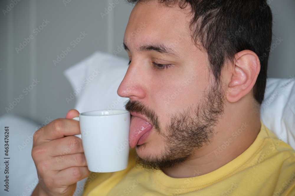 Sleepy guy sucking a cup of coffee. Sleepy guy sucking a cup of coffee.