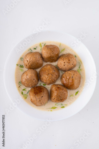 Vegan meatballs with cream sauce and on a white plate. White background, top view