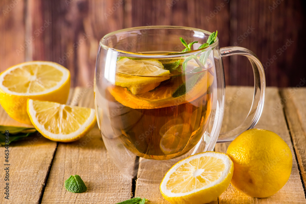 Herbal tea with lemon and mint on wooden background. Delicious drink for relaxation and alternative therapy of diseases. Herbal tea with lemon and mint on wooden background. Delicious drink for relaxation and alternative therapy of diseases.