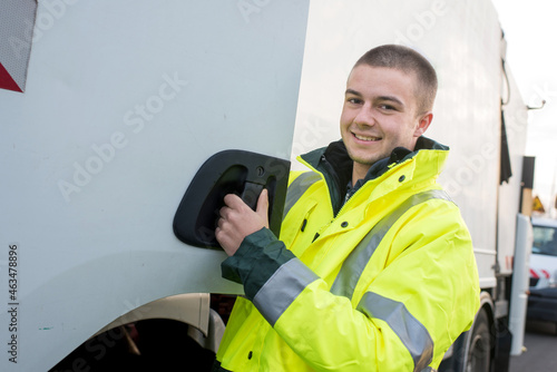 garbage collector smiling next to the truck photo