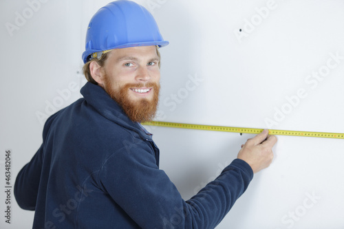 a man measuring a wall using a ruler