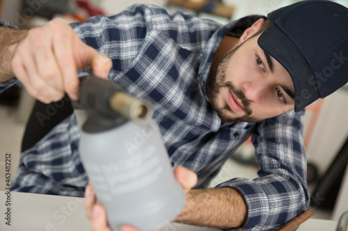 Fotografía man unscrews the valve from the gas bottle