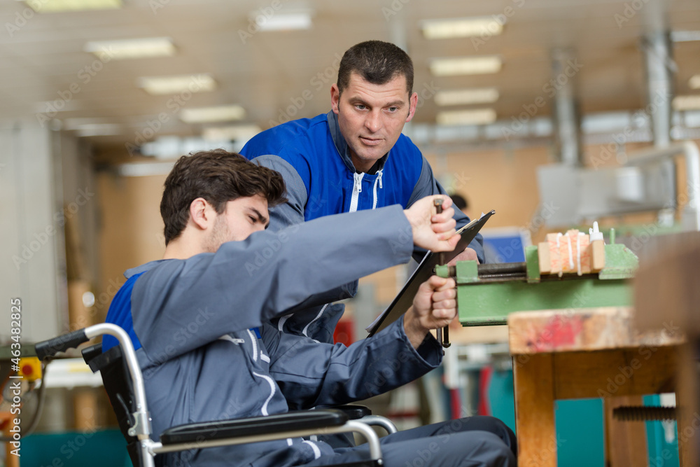 disabled worker in wheelchair in a carpenters workshop disabled worker in wheelchair in a carpenters workshop
