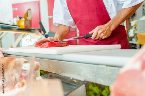 a butcher is cutting meat