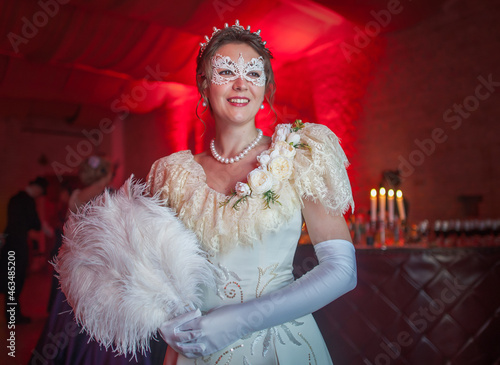 Woman in 19th century dress with candles at the royal ball in the castle