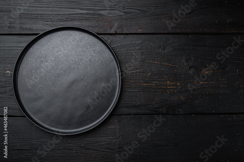 Empty black plate, on black wooden table background