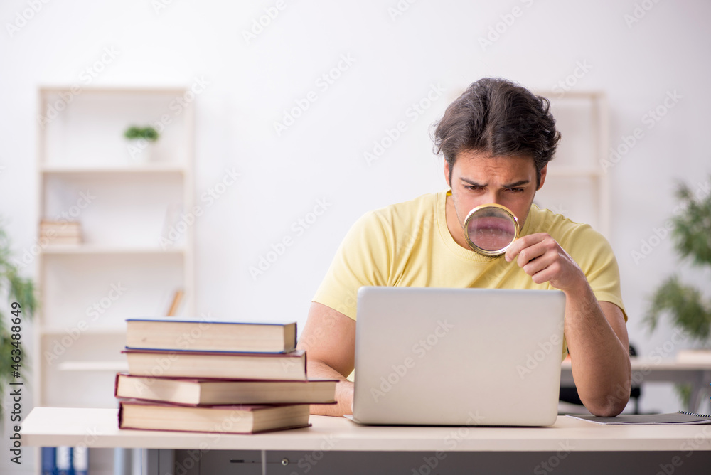 Young male student in telestudying concept Young male student in telestudying concept