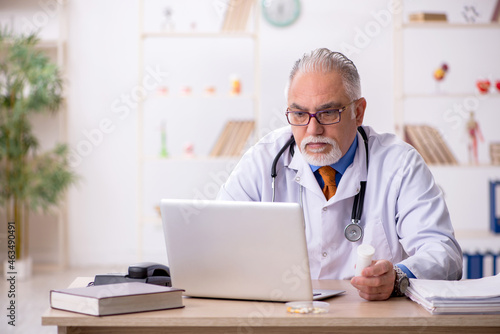 Old male doctor working in the clinic